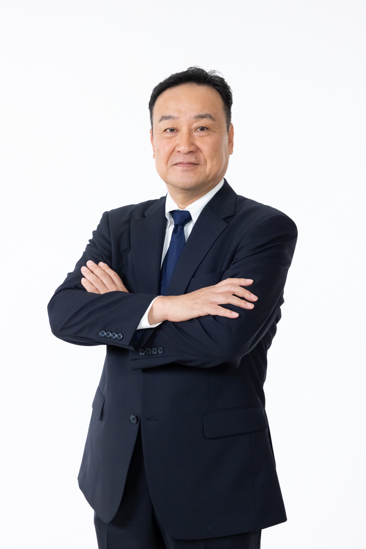 腕を組んで立つ代表取締役の末澤秀雄